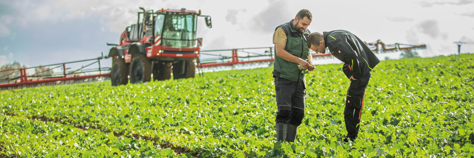 In a field, two men use an Agrifac sprayer to spray crops, promoting agricultural productivity and crop health.