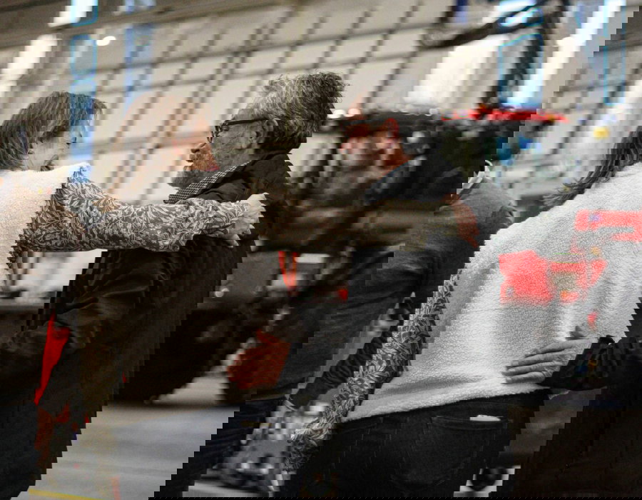 Employees greeting each other inside a factory environment.