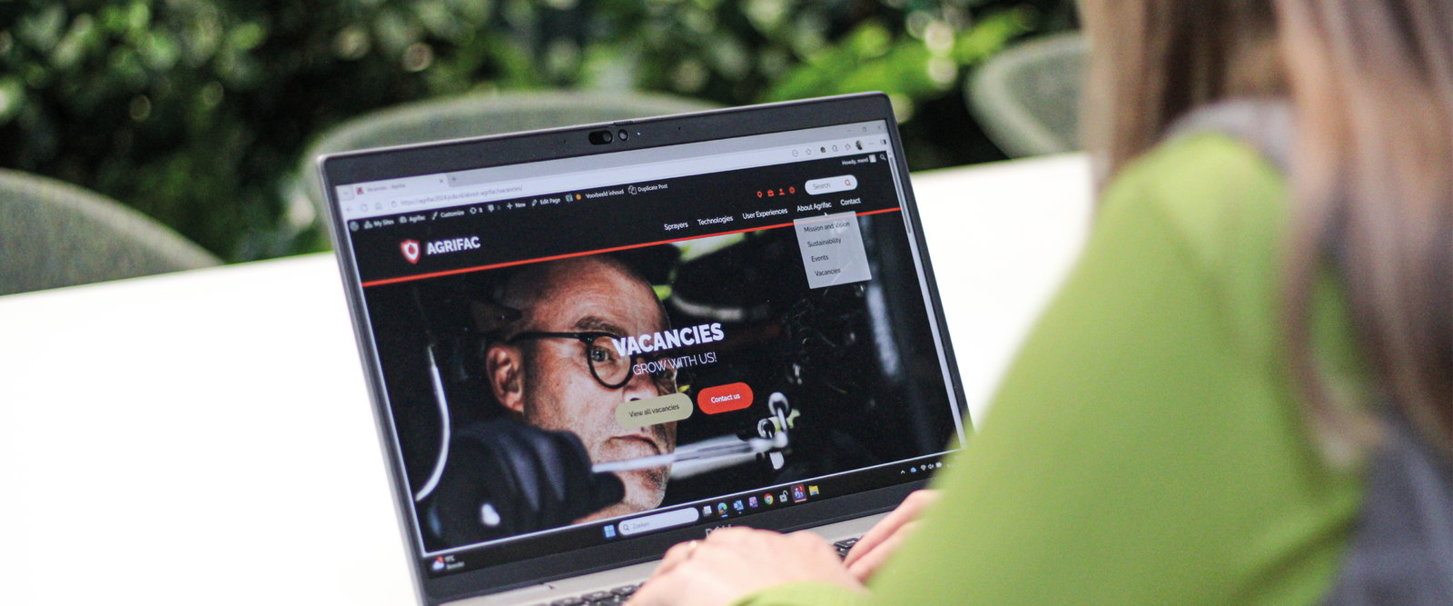 Person sitting behind a laptop.