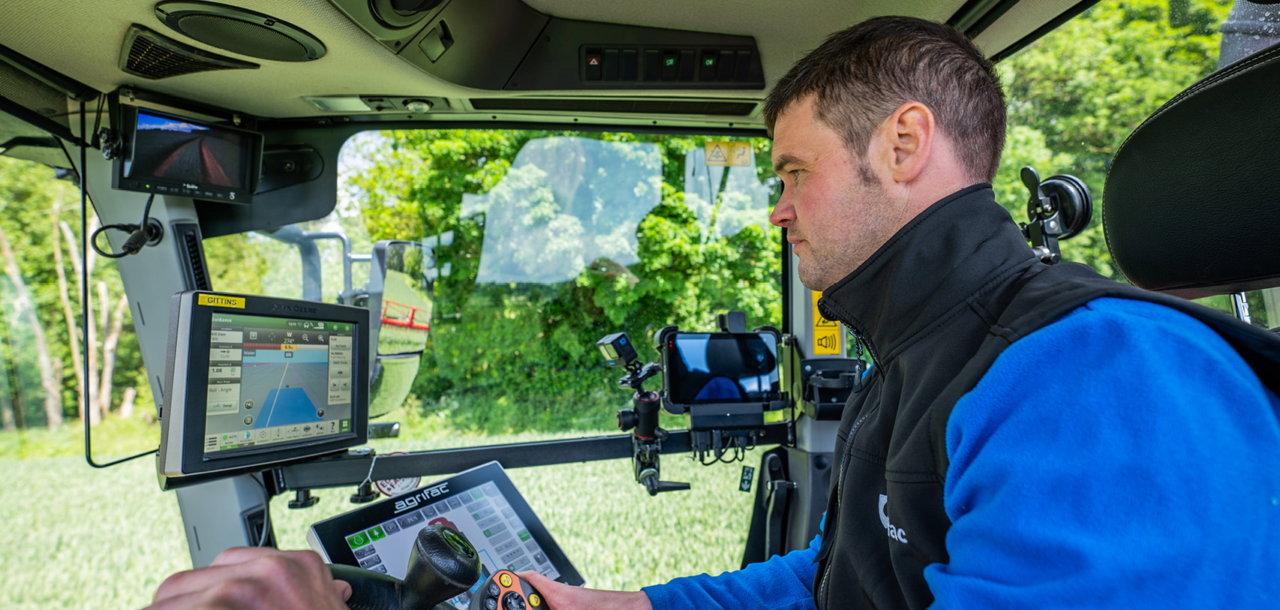 A person sitting in the cab of an Agrifac Condor Vanguard.