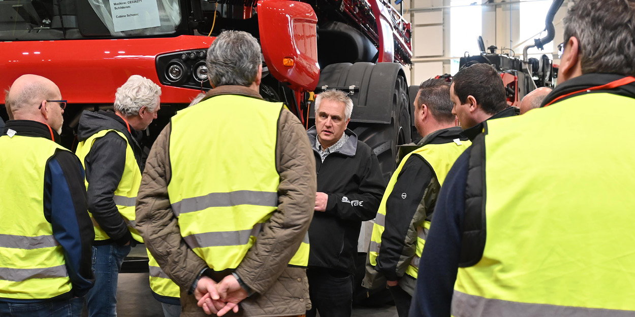 Group discussing an Agrifac sprayer inside the factory.