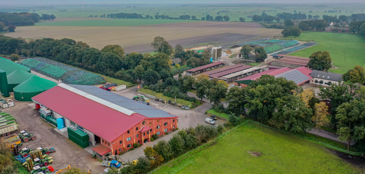 Aerial view showcasing a picturesque countryside farm with barns surrounded by lush fields and greenery.
