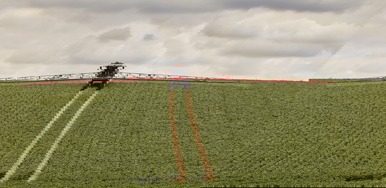 Agrifac sprayer spraying in a green field.