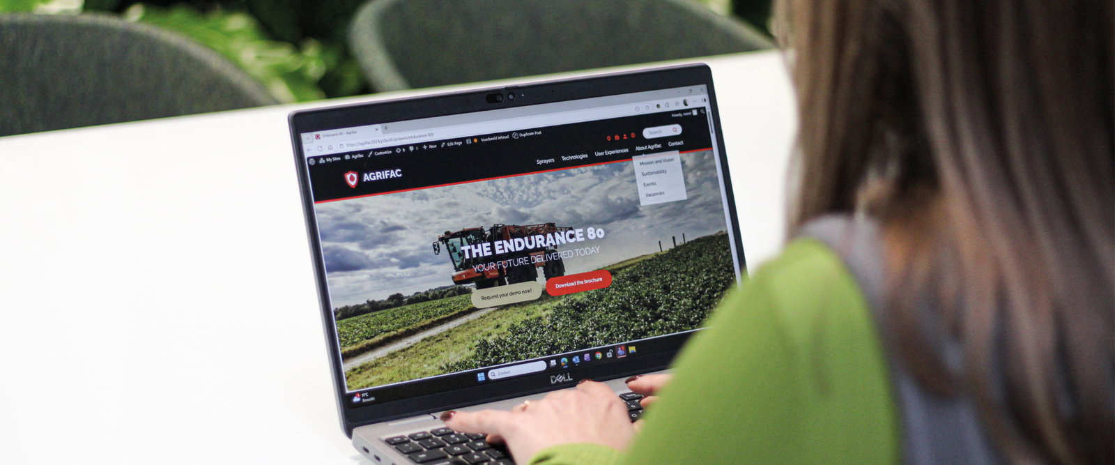 Person sitting behind a laptop.