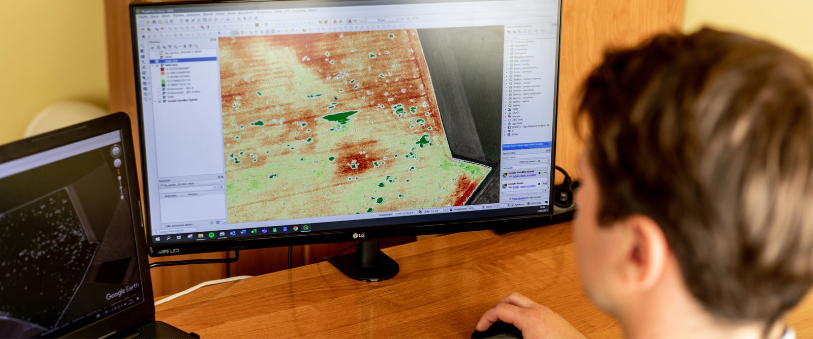 A man sits at a desk, focused on a computer screen displaying a detailed task map for navigation or planning purposes.