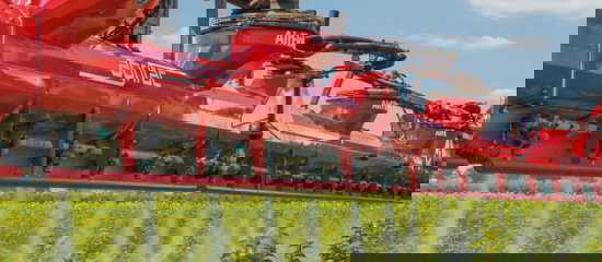 An Agrifac sprayer with AirFlow boom, spraying a green field, showcasing agricultural action and drift reduction.