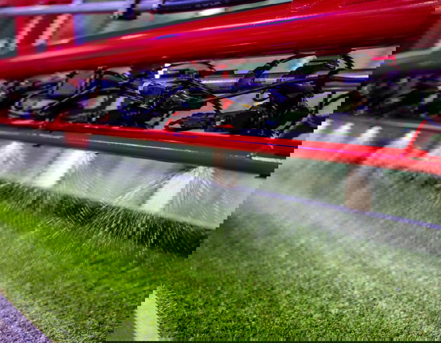 Agricultural spray boom demo model actively spraying.